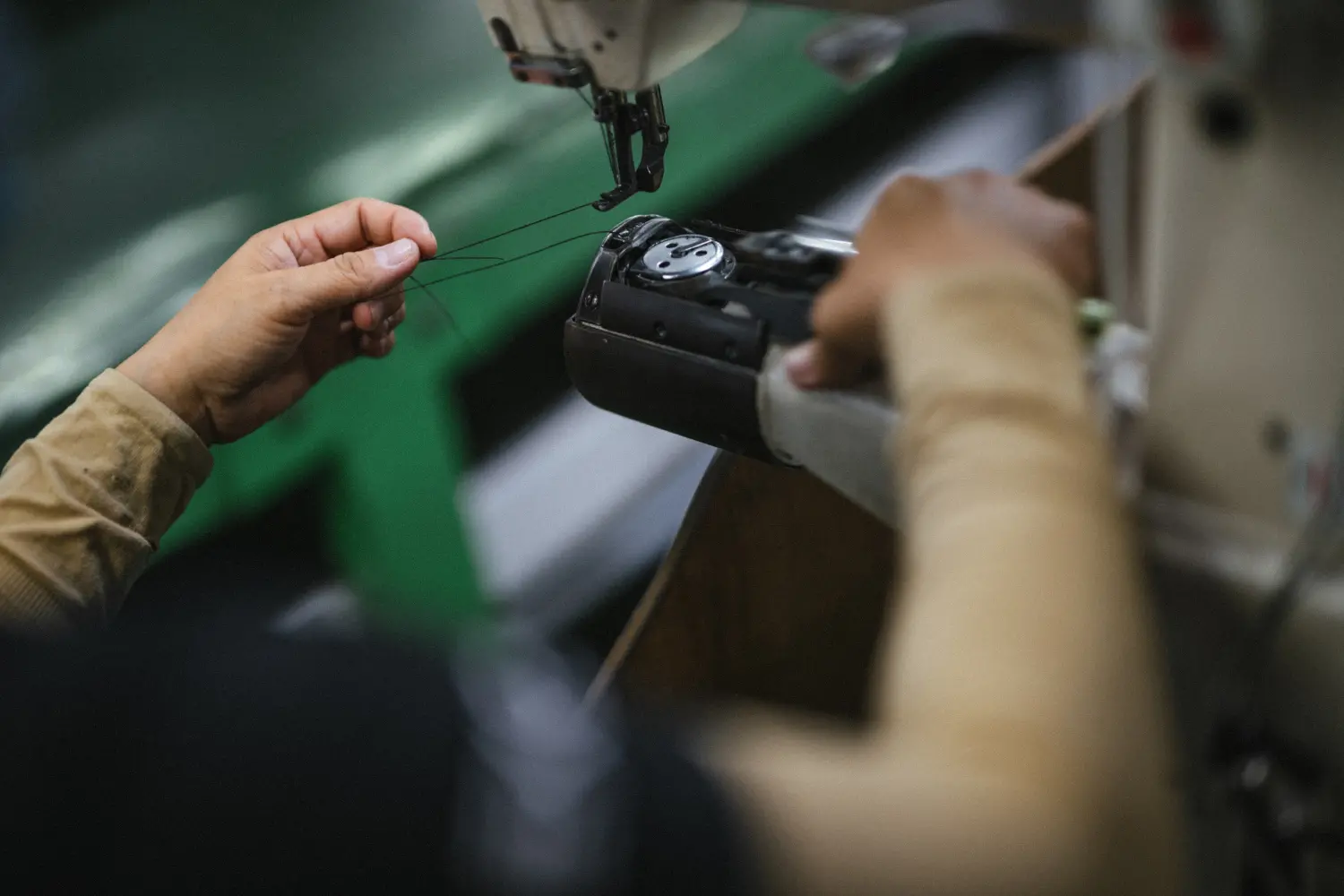 A photo of a spool of thread being loaded into a machine.